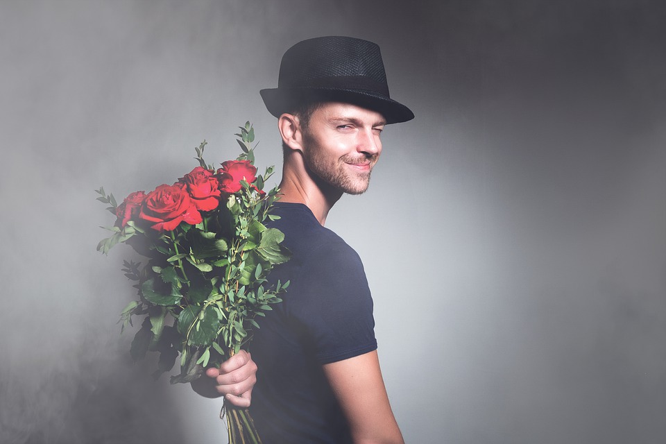 Muž s kytkou růží za zády